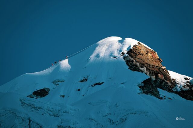 Sunrise with the Life Happens Outdoors team moments from the top, as seen from the Island Peak glacier during the Climb Island Peak Expedition.