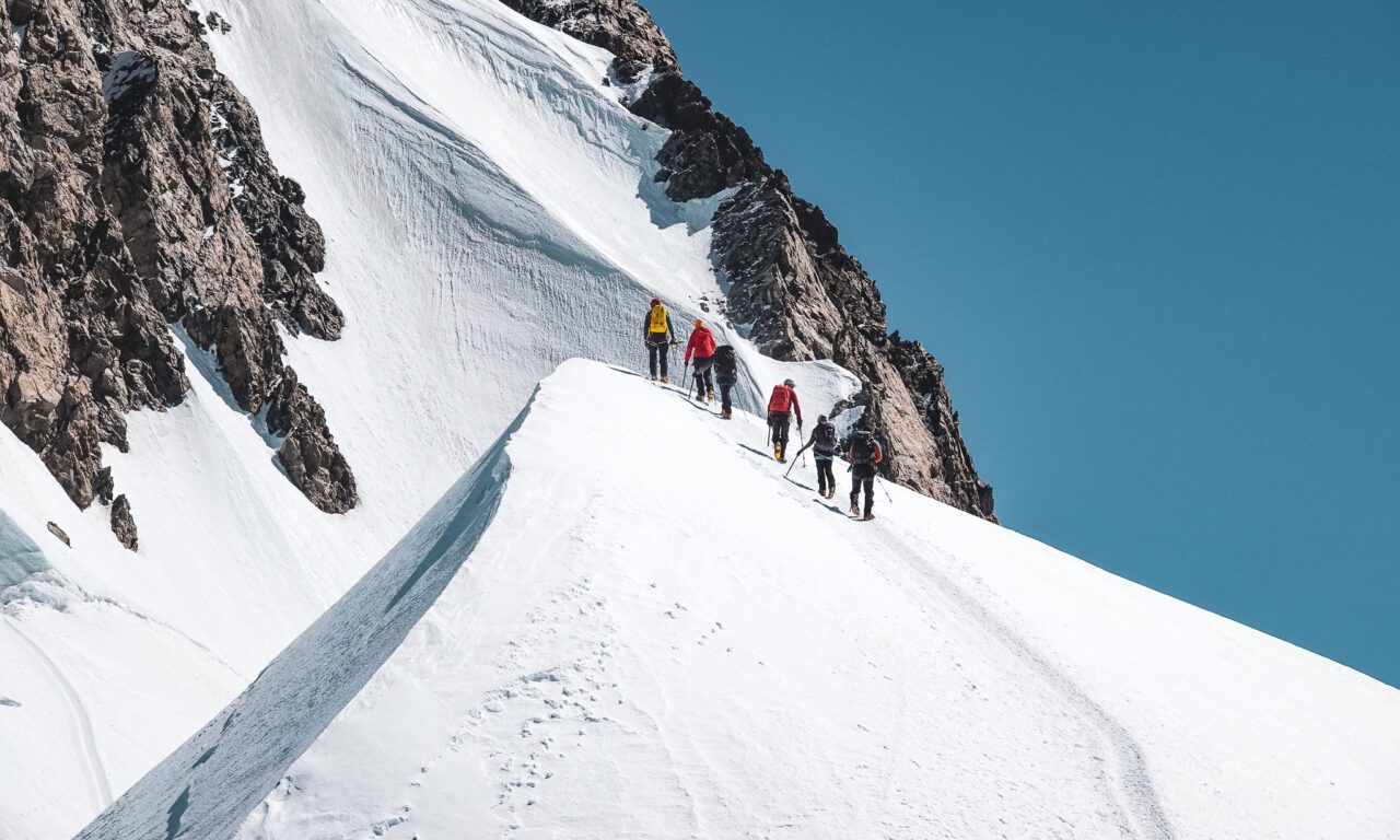 The LHO team moving along a snowy ridge during a Mont Blanc climbing course.