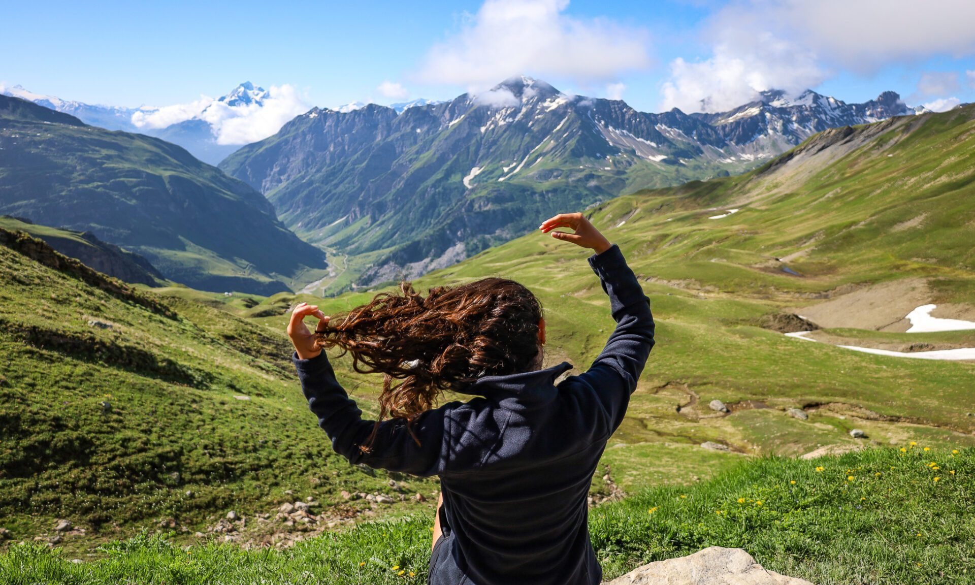 An LHO trekker looking across Alpine valleys on the Tour du Mont Blanc.