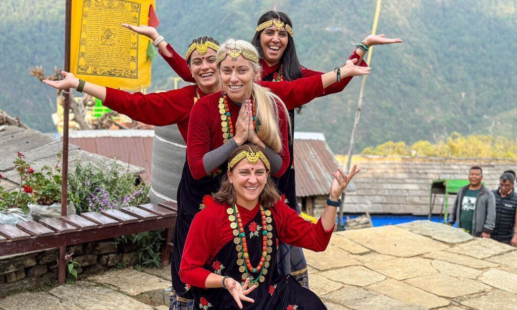 The Life Happens Outdoors team soaking in the culture of Ghandruk, dressed in traditional Nepali garments, during the Annapurna Base Camp Trek.