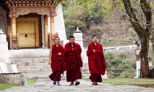 Monks walking through Punakha Dzong, a cultural highlight of Bhutan explored during the Life Happens Outdoors adventure tour