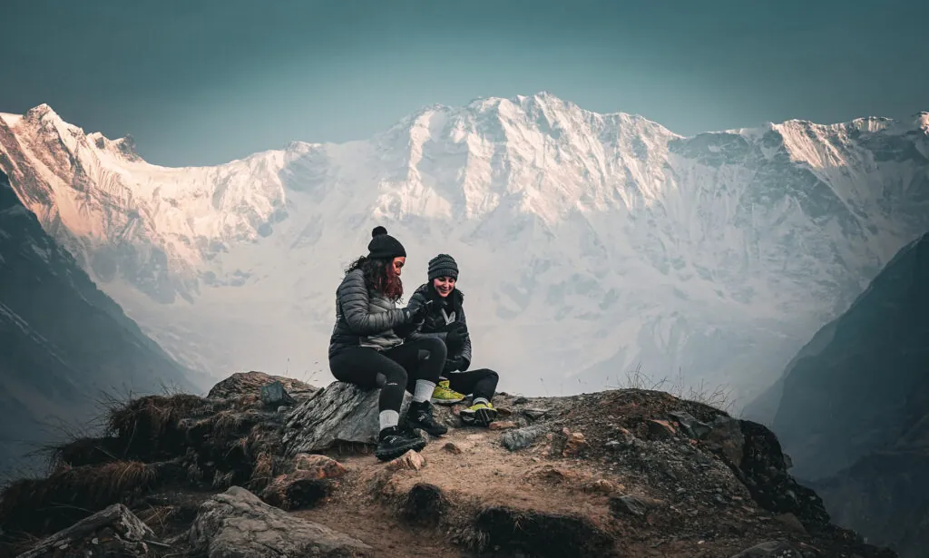 Two Life Happens Outdoors community members watching sunrise beneath the south face of Annapurna during the Annapurna Base Camp trek.