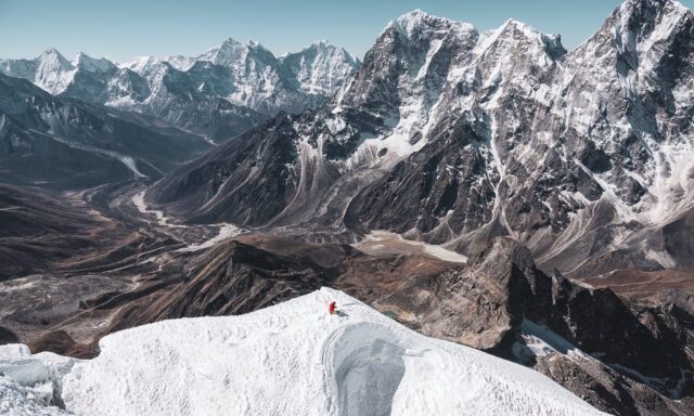 LHO climber beneath the summit of Lobuche East, waiting for the guide to assist on the final fixed rope to the summit, with the stunning Pheriche Valley below.