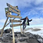 The summit sign at the top of Mount Kilimanjaro during the Climb Kilimanjaro Expedition with the Life Happens Outdoors team.