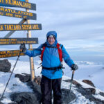 Uhuru Peak at the summit sign during the Climb Kilimanjaro Expedition with the Life Happens Outdoors team.