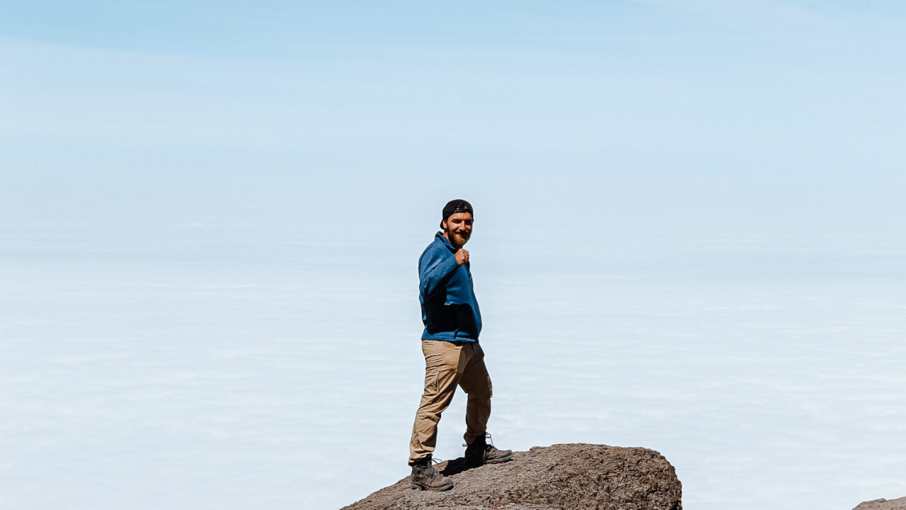 An LHO climber celebrating after ascending the Barranco Wall on Kilimanjaro.