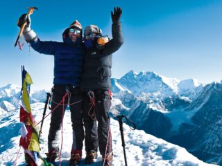 Two climbers celebrating on the summit of Mera Peak above Nepal’s Hinku Valley.
