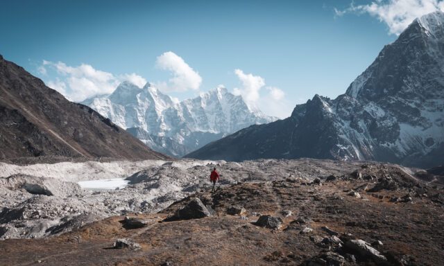 LHOer walking next to the lower Khumbu Glacier above Lobuche town on the day before reaching Everest Base Camp, with Cholatse and Thamserku in the background during the Everest Base Camp Trek with the Life Happens Outdoors team.