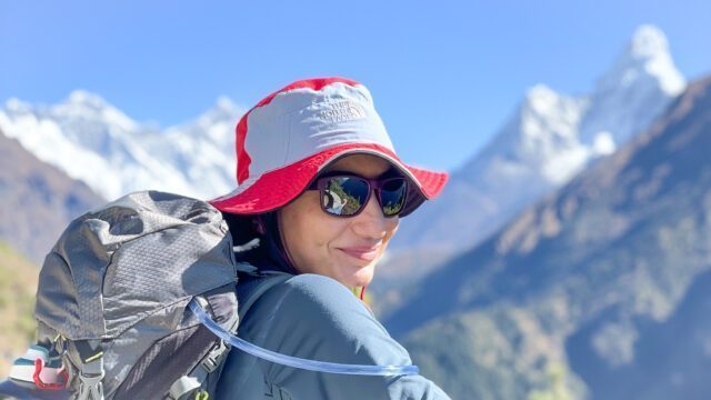 LHOer Nour Arar above Namche Bazaar on our way to Tengboche Monastery. Ama Dablam, Everest, and Lhotse can be seen in the background on a beautiful blue sky day at the junction between the Khumbu Valley and Gokyo Valley during the Everest Base Camp Trek with the Life Happens Outdoors team.