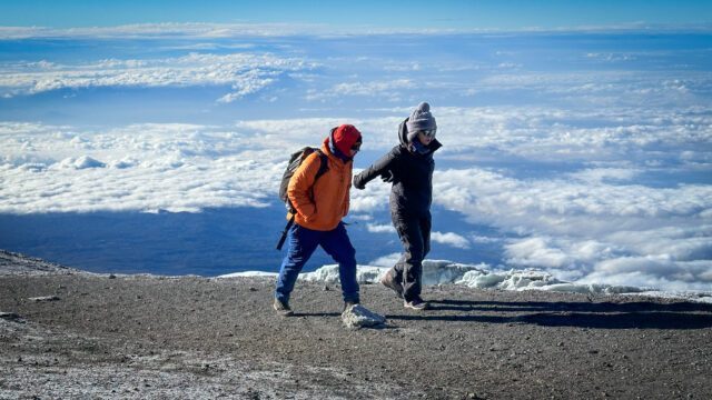 LHO Team Leader Hazem El Shamy and Leen Madanat on the final stretch to the Uhuru Peak summit of Kilimanjaro during the Climb Kilimanjaro Expedition with the Life Happens Outdoors team.