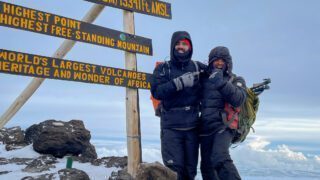 LHO Team Leader Jean Louis Moukarzel and LHO Kilimanjaro guide Saidi at the summit sign of Uhuru Peak on the summit of Mount Kilimanjaro during the Climb Kilimanjaro Expedition with the Life Happens Outdoors team.