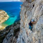 LHOer climbing over the sea on a remote beach only accessible by boat during the Rock Climbing in Kalymnos adventure with the Life Happens Outdoors team.