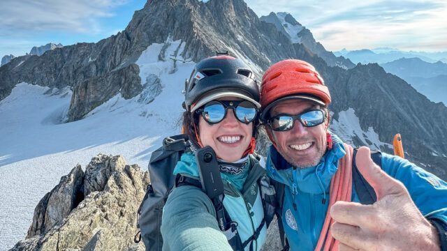 Nelly Attar and IFMGA guide François Xavier on the summit of Aiguille d'Entreves during the training and acclimatization portion of the Eiger course, with the Dent du Géant in the background and incredible views across the Glacier du Géant and the Vallée Blanche.