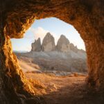 Tre Cime di Lavaredo viewed through a natural cave opening in the Dolomites, part of the dramatic alpine scenery on the LHO Dolomites via ferrata tour