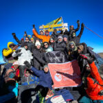 climbers stand on the summit of mount kilimanjaro, uhuru peak