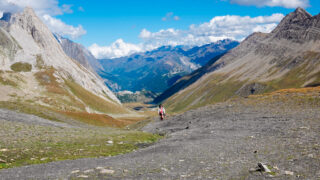 on the tour du mont blanc hike, mountain peaks surround a valley below
