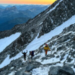 LHOers Hannah Piercy and Gino Traboulsi being led by LHO IFMGA mountain guide Pavlos Tsiantos across the Grand Couloir during the summit push of Mont Blanc with the Life Happens Outdoors team.
