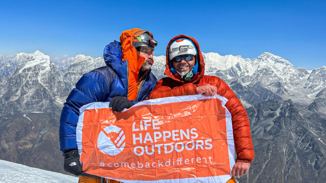 Rami Rasamny and LHO mountaineer Tony Aoun on the summit of Ama Dablam holding the Life Happens Outdoors flag, symbolizing adventure travel and transformation.