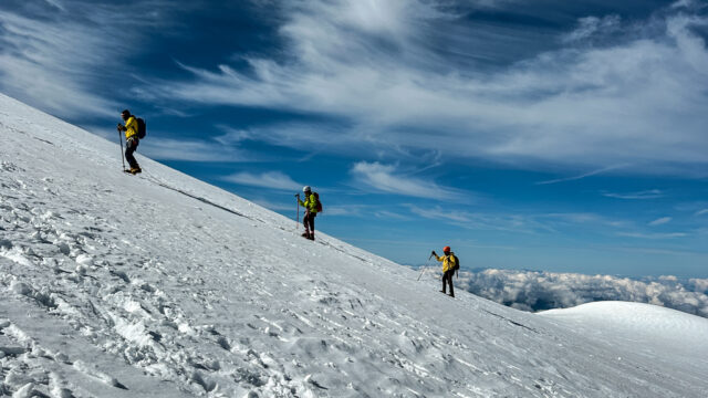 Three Life Happens Outdoors climbers led by guide Babis Marinidis ascending the face of the Dome du Gouter on the classic Mont Blanc climb route