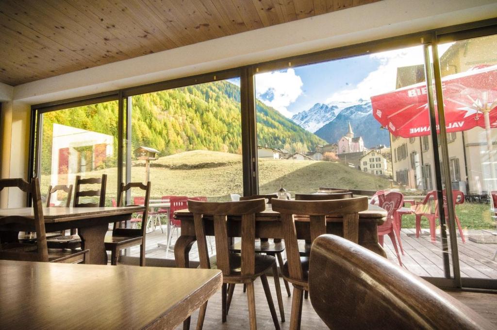 Restaurant area of Auberge du Mont Blanc with wooden tables and large windows offering a clear view of Trient’s iconic pink church.