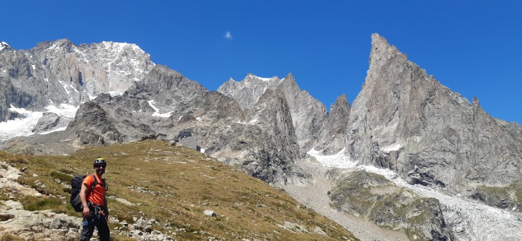 Jean Louis Moukarzel of Life Happens Outdoors standing outside the Monzino Hut during the training stage of his week, surrounded by rugged alpine terrain and towering peaks, preparing for his climb of the Eiger as part of his journey recounted in the article 