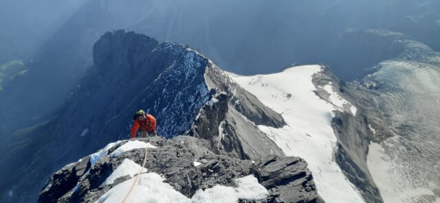 Jean Louis Moukarzel of Life Happens Outdoors ascending the narrow, snow-covered Mitellegi Ridge of the Eiger, surrounded by dramatic alpine peaks and deep valleys, capturing the challenge and beauty of his journey as recounted in the article 
