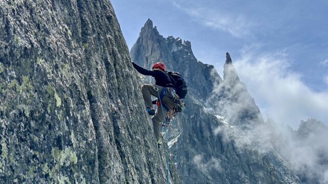 LHO Team Leader Gino Traboulsi climbing a granite route in Chamonix with Mont Blanc peaks in the background, showcasing balance, focus, and the Life Happens Outdoors spirit of transformation.