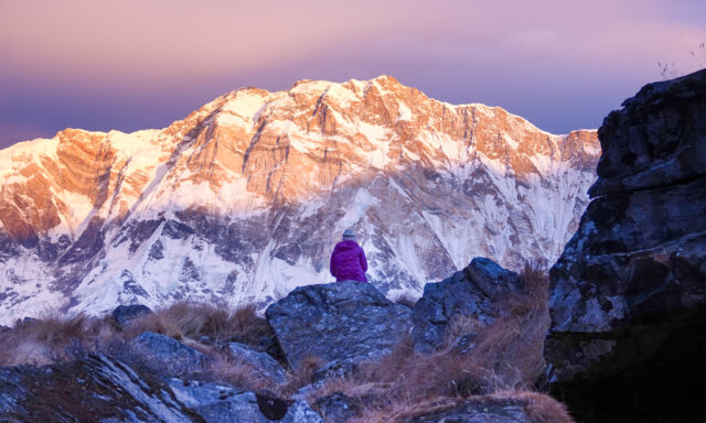 A Life Happens Outdoors community member stands in quiet contemplation at sunrise, gazing toward the towering south face of Annapurna.