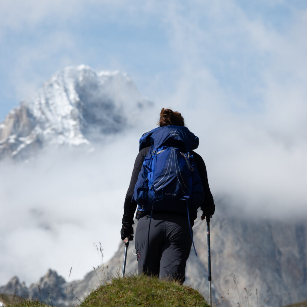 Life Happens Outdoors community member hiking the Tour du Mont Blanc with the Mont Blanc massif rising above the clouds.
