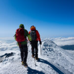 First time climber from the Life Happens Outdoors community descending Mont Blanc with the summit ridge and Bosses Ridge visible in ideal alpine conditions.