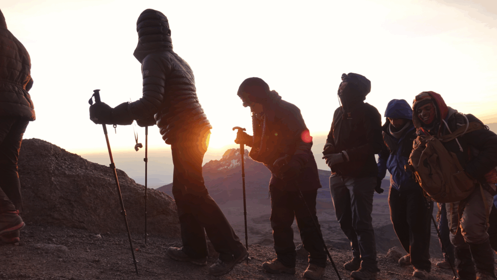 Life Happens Outdoors team watching sunrise behind Mount Mwenzi near Stella Point on the Machame Route of the Kilimanjaro climb