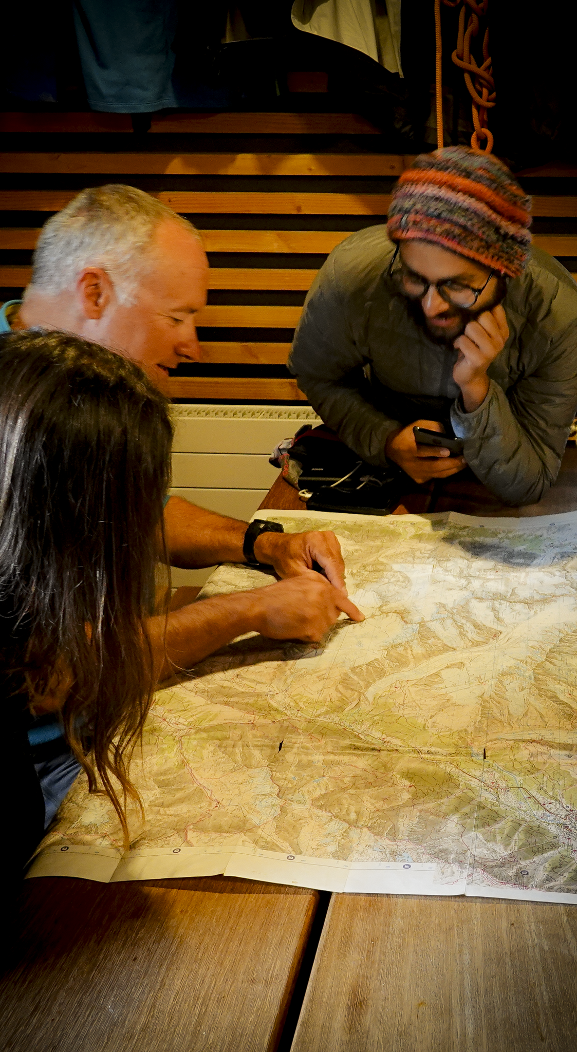 Life Happens Outdoors community members and their guide reviewing a mountain map during a route briefing.