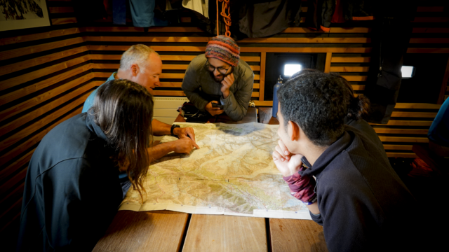 Life Happens Outdoors corporate joiners and their guide review a map and discuss the day’s objective during a corporate adventure retreat planning session