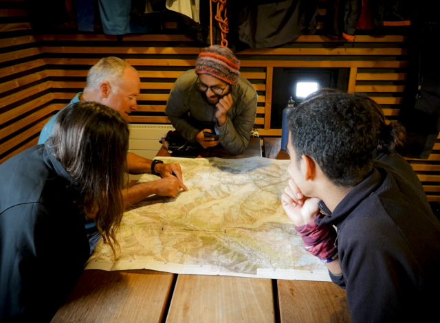 Life Happens Outdoors corporate joiners and their guide review a map and discuss the day’s objective during a corporate adventure retreat planning session