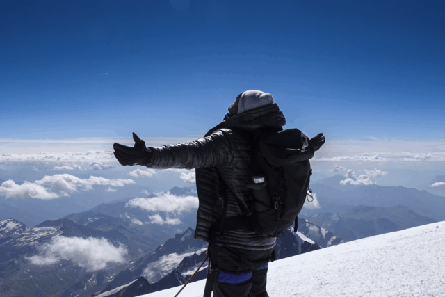 Life Happens Outdoors climber standing on the summit of Mont Blanc at 4,810 m, celebrating a successful ascent.