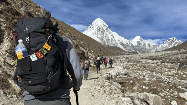 Life Happens Outdoors community members trekking toward Everest Base Camp with Pumori mountain in the distance on the EBC trail
