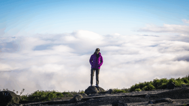 Life Happens Outdoors community member posing on Kilimanjaro with a sea of clouds behind them in clear weather