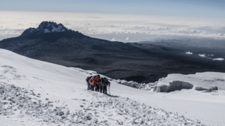 Life Happens Outdoors community members climbing as one group on the final stages of the Kilimanjaro summit push.