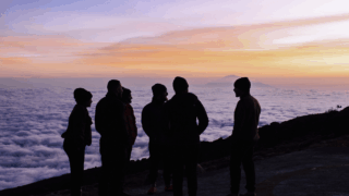 Life Happens Outdoors community members chatting together with a dramatic sunset backdrop on Kilimanjaro.