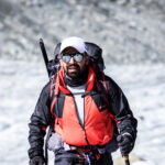Life Happens Outdoors community member trekking the Chamonix to Zermatt Haute Route with alpine peaks in the background.