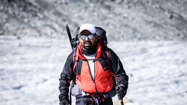 Life Happens Outdoors community member trekking the Chamonix to Zermatt Haute Route with alpine peaks in the background.
