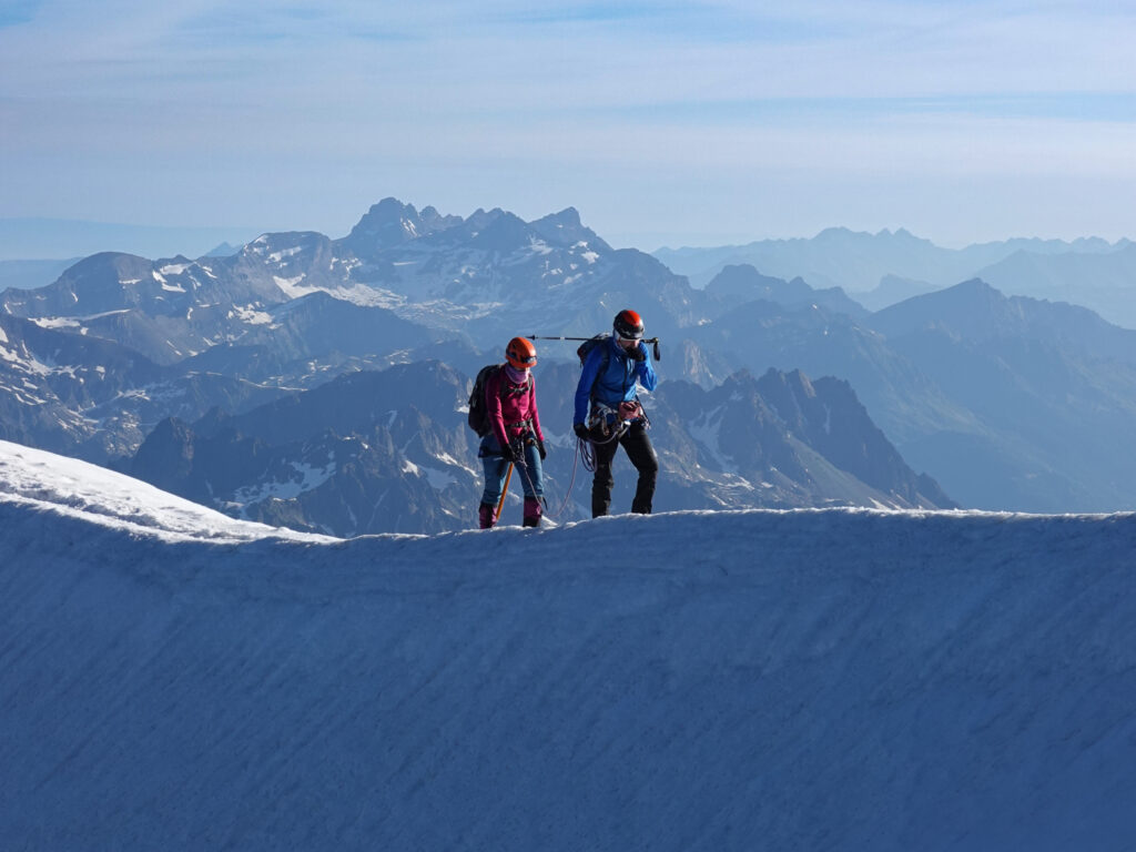 Two Life Happens Outdoors guides with an LHO community member climbing Mont Blanc, with Aiguille Rouge in the background.