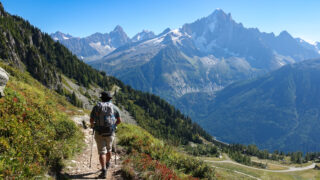 Hiker on a mountain trail above Chamonix with views across the Mont Blanc massif