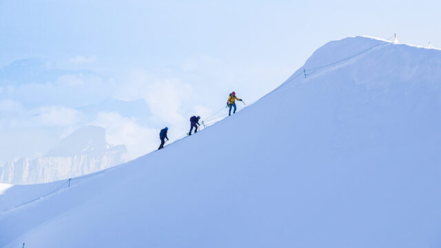 Roped climbers with a guide ascending Mont Blanc in snowy conditions