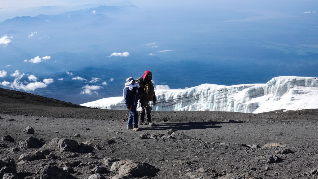 Climber and guide walking near the glacier at the summit of Kilimanjaro
