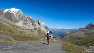 Solo hiker walking a mountain trail during a guided hiking trip in the Alps