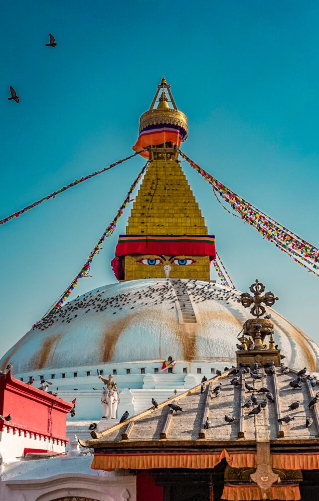 Boudhanath Stupa in Kathmandu Nepal with prayer flags and blue sky