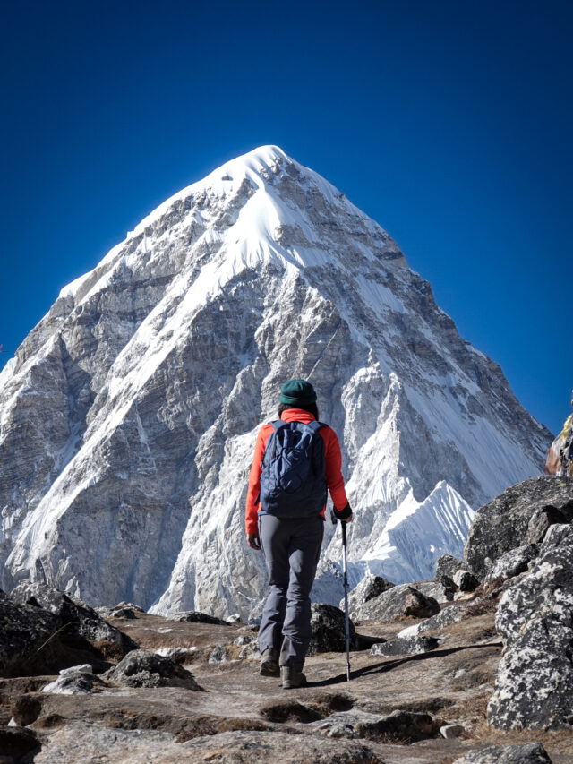 Trekker approaching a high Himalayan peak on a mountain trail in Nepal