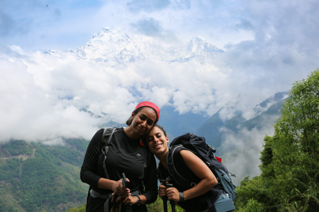 Two trekkers on the Annapurna Base Camp trek in Nepal with cloud covered mountain views