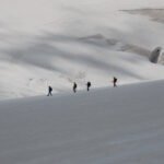 A traveler looks out toward a traditional Himalayan monastery fortress framed by forested mountains, reflecting on the journey and shared adventure